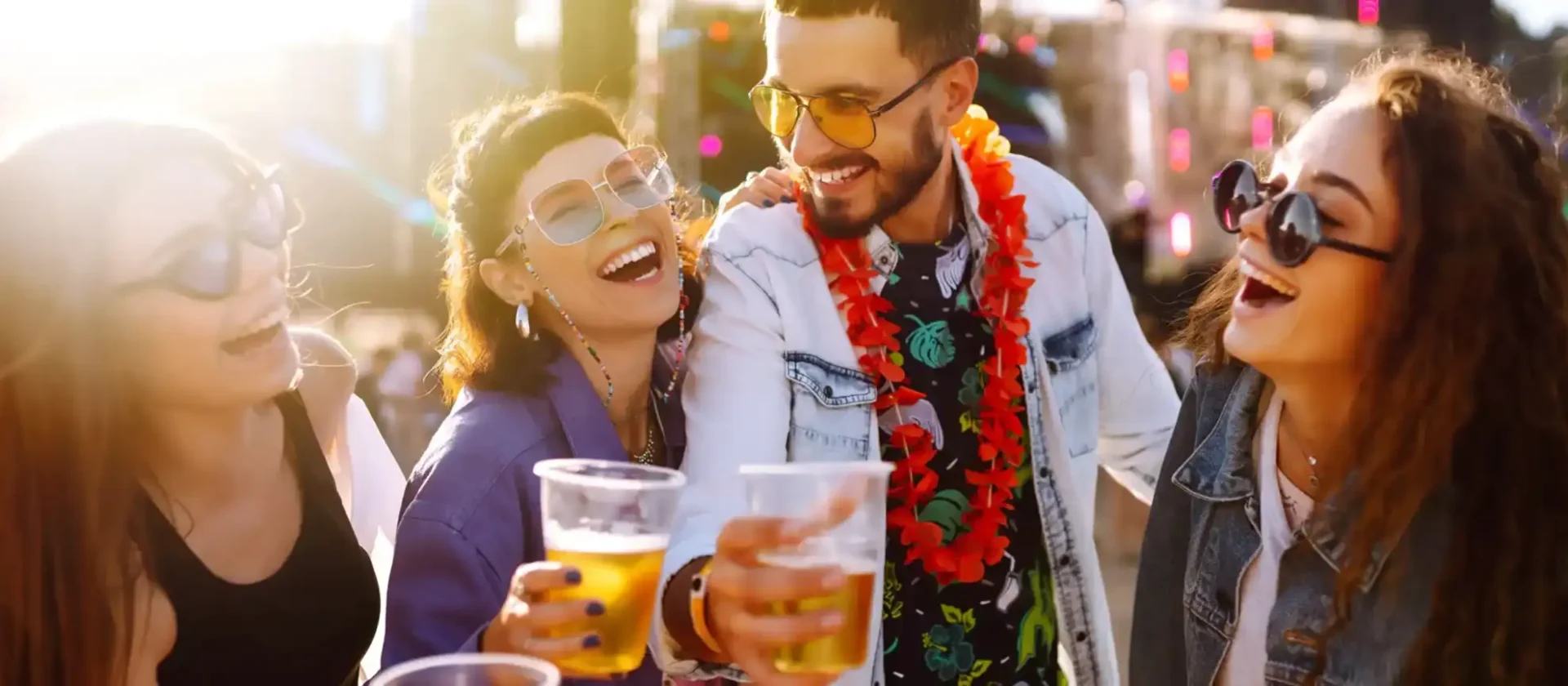 Friends laughing and toasting with drinks at an outdoor festival at Wvec West Valley Events Complex, Phoenix, Arizona.