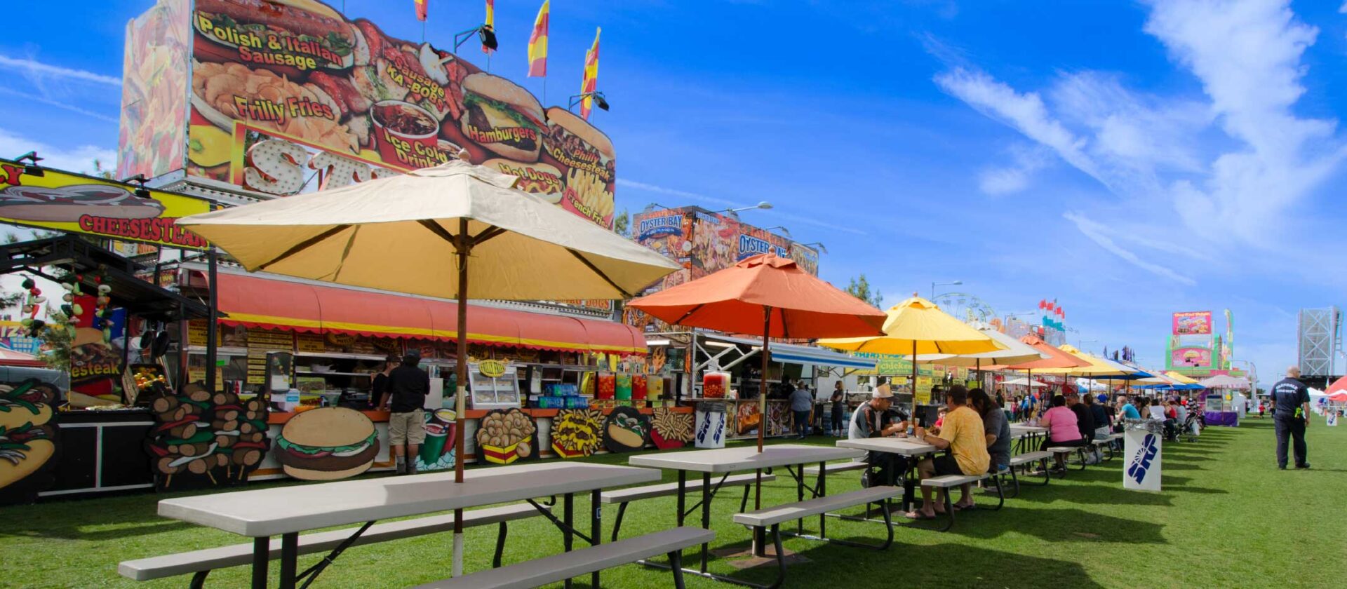 Outdoor food court with colorful umbrellas and dining area at Wvec West Valley Events Complex, Phoenix, Arizona.